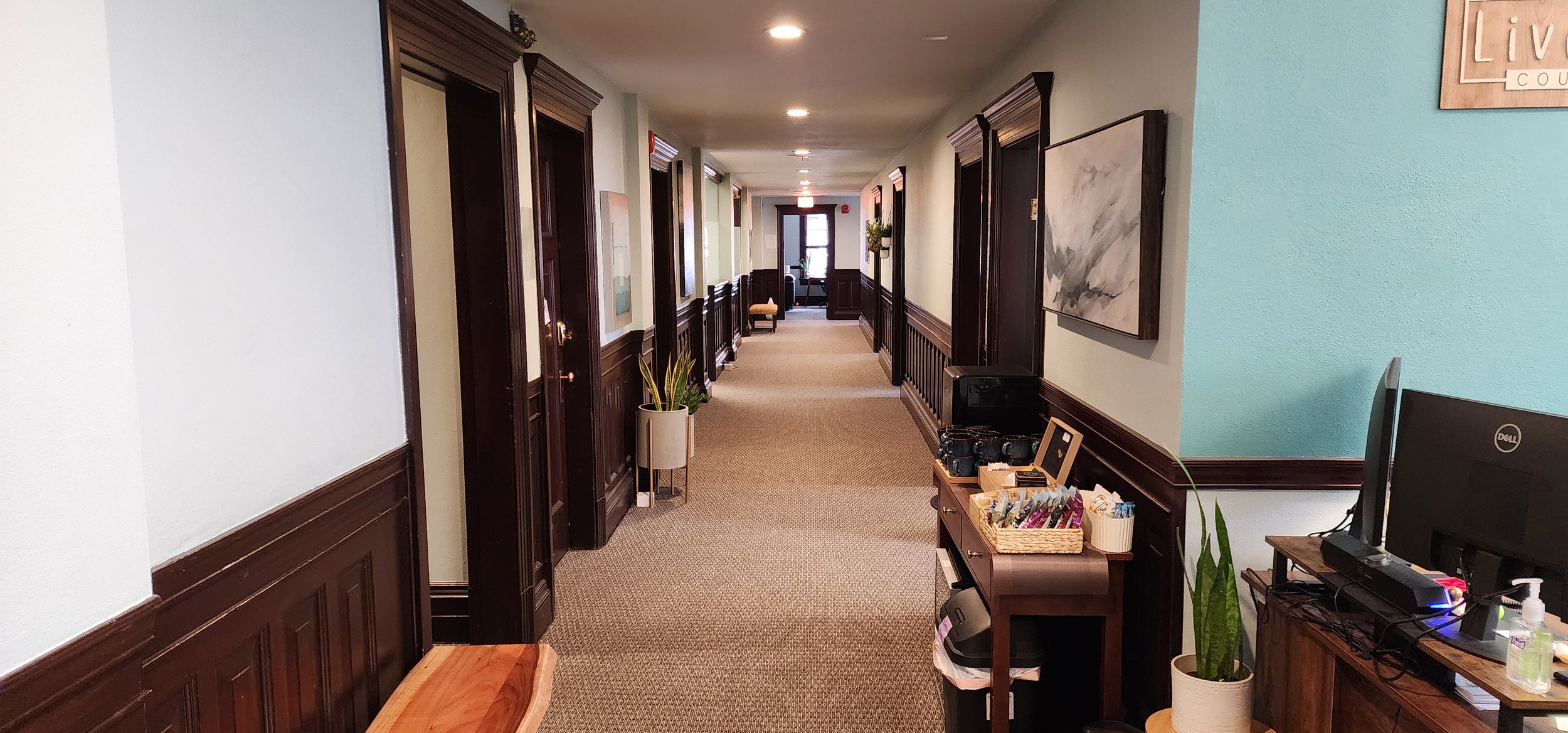 Therapy office with sofa, chair, and artwork