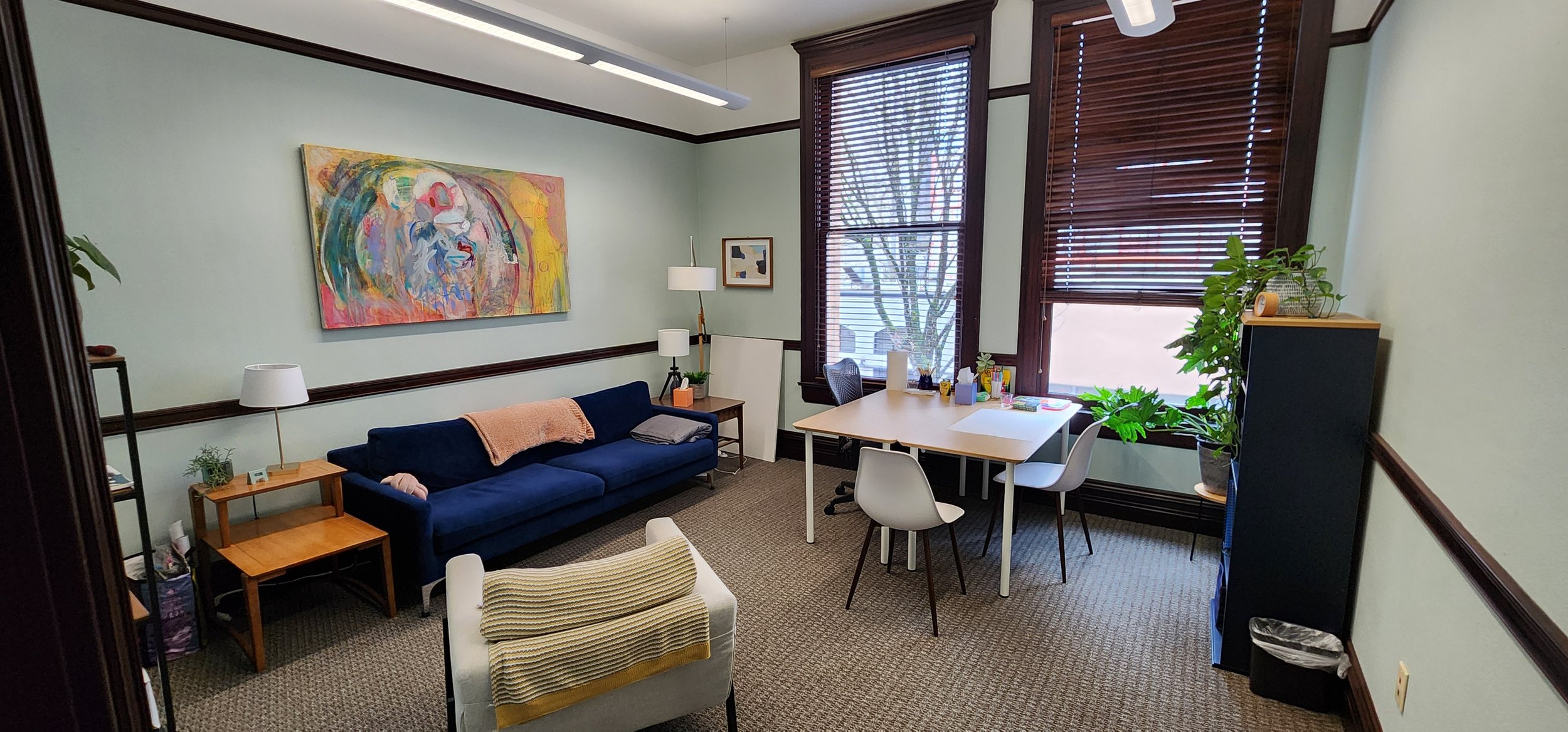 Private therapy office with seating and tall window